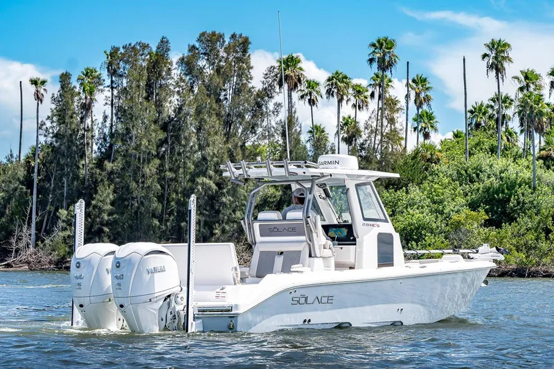 Slide: The Image of Manufacturer Provided Image: 2026 Solace 28 HCS boat cruising on water with lush greenery background. - 5