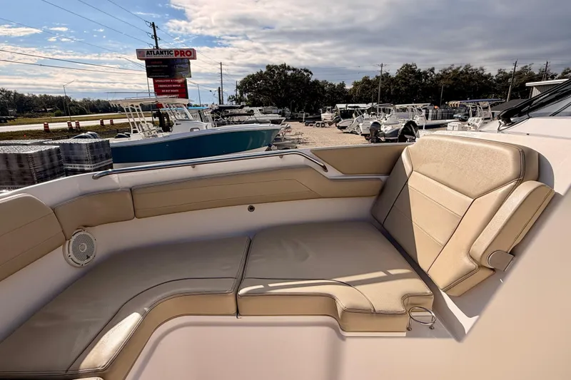 Slide: The Image of 2018 Pursuit DC 365 Dual Console boat interior with beige seating and cup holder. - 10