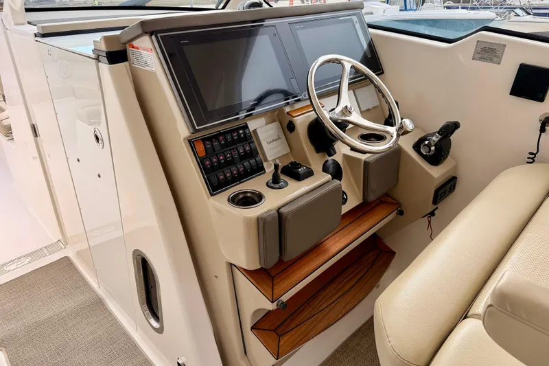 Slide: The Image of 2018 Pursuit DC 365 Dual Console boat helm with steering wheel and control panel. - 14