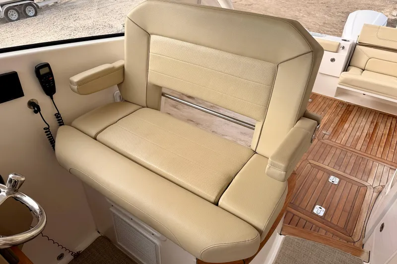 Slide: The Image of 2018 Pursuit DC 365 Dual Console boat interior with beige seating and wooden flooring. - 22