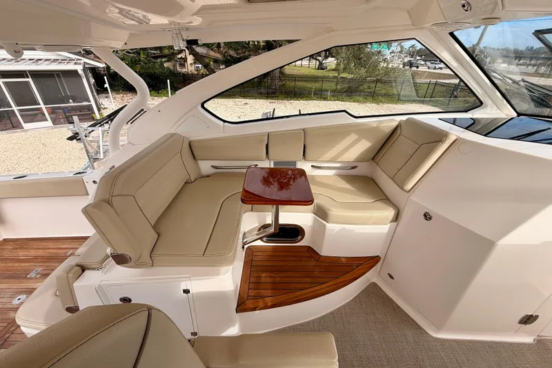 Slide: The Image of 2018 Pursuit DC 365 Dual Console interior with beige seating and wooden accents. - 23