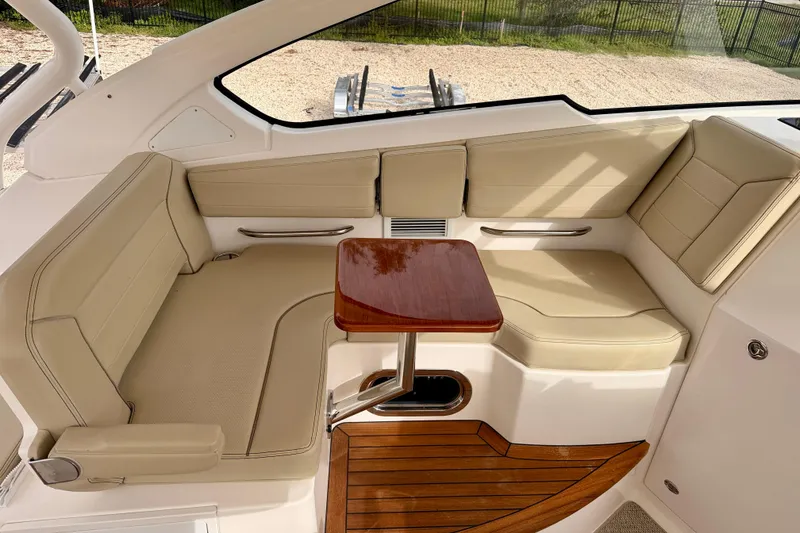 Slide: The Image of Luxurious seating area on 2018 Pursuit DC 365 Dual Console boat with wooden table. - 24