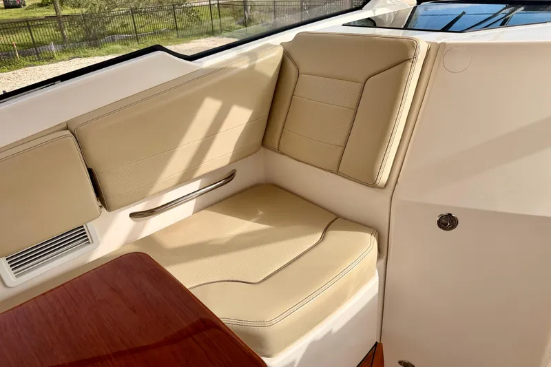 Slide: The Image of Luxurious seating on 2018 Pursuit DC 365 Dual Console boat, featuring beige upholstery and wooden accents. - 25