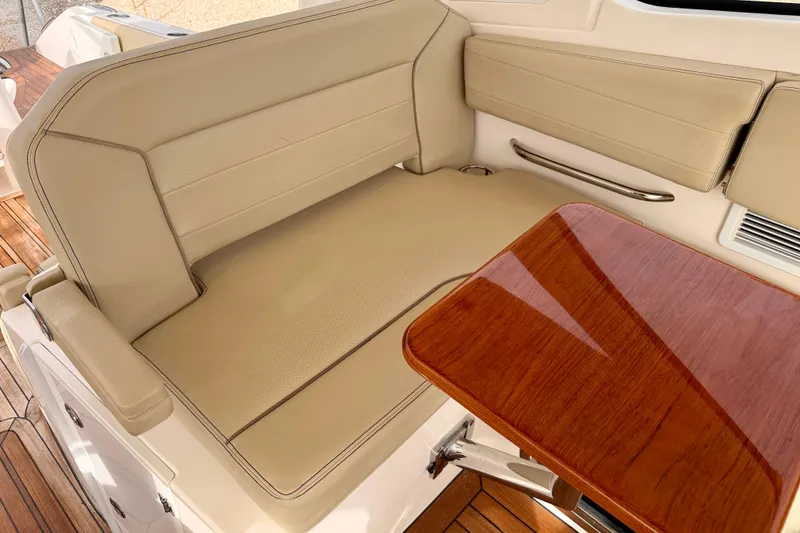 Slide: The Image of Luxurious seating area on 2018 Pursuit DC 365 Dual Console boat with wooden table. - 26