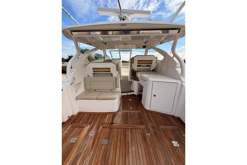 Slide: The Image of 2018 Pursuit DC 365 Dual Console boat interior with teak flooring and cushioned seating. - 27