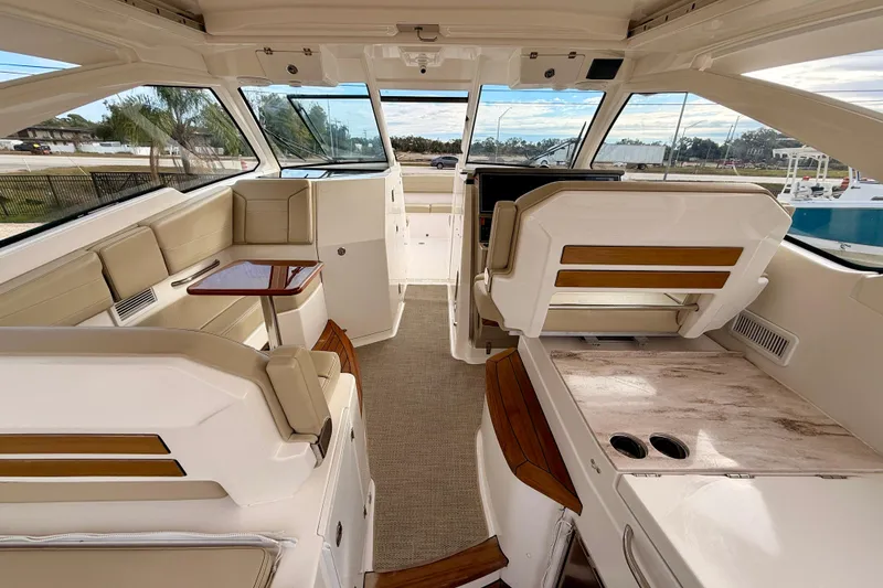 Slide: The Image of 2018 Pursuit DC 365 Dual Console interior with seating, table, and helm station. - 29