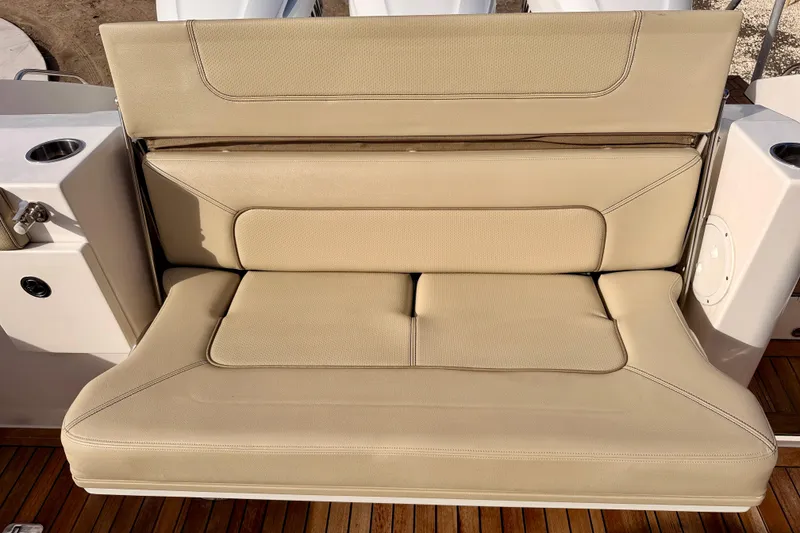 Slide: The Image of Beige seating on 2018 Pursuit DC 365 Dual Console boat, featuring cup holders and wooden deck. - 33