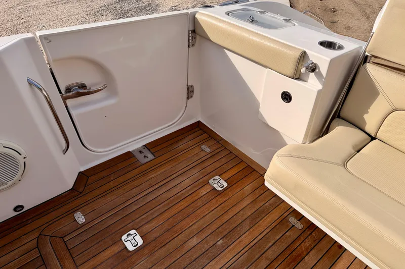 Slide: The Image of 2018 Pursuit DC 365 Dual Console boat interior with teak flooring and beige seating. - 34