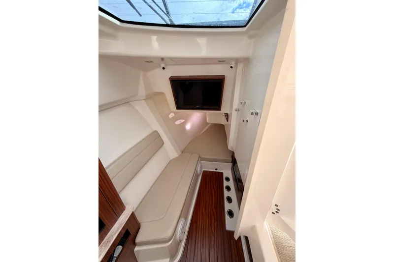 Slide: The Image of Interior cabin of 2018 Pursuit DC 365 Dual Console boat with seating and TV. - 37