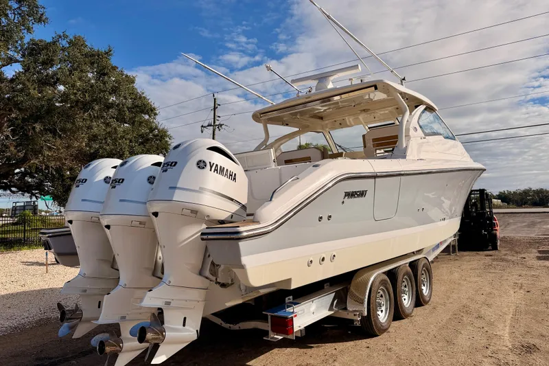 Slide: The Image of 2018 Pursuit DC 365 Dual Console boat with triple Yamaha outboard engines on a trailer. - 4