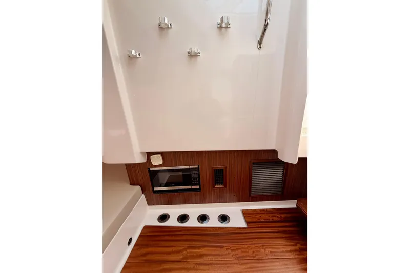 Slide: The Image of 2018 Pursuit DC 365 Dual Console interior with microwave and wood accents. - 41