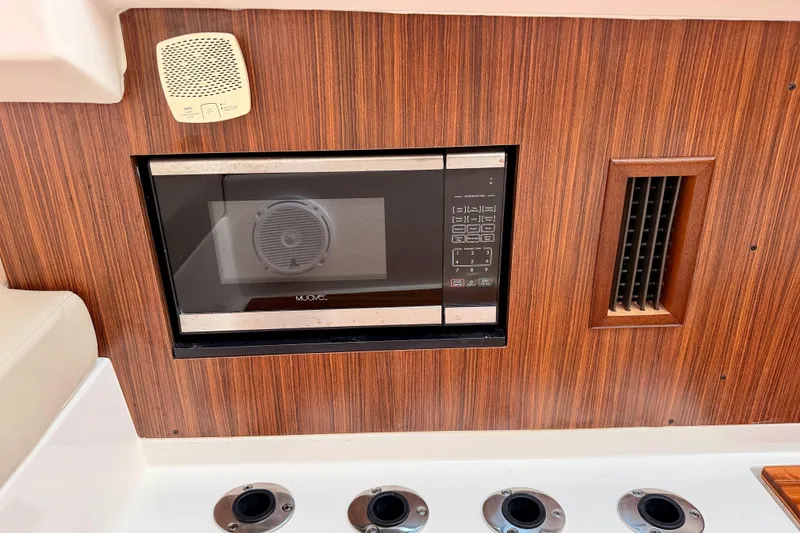 Slide: The Image of 2018 Pursuit DC 365 Dual Console interior with built-in microwave and wood paneling. - 43