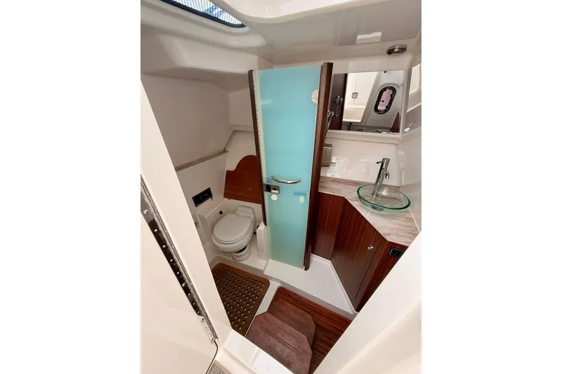 Slide: The Image of Luxurious 2018 Pursuit DC 365 boat bathroom with modern fixtures and elegant wood accents. - 46