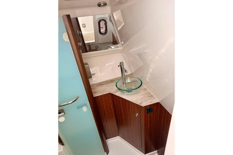 Slide: The Image of 2018 Pursuit DC 365 Dual Console bathroom with modern sink and wooden cabinetry. - 47