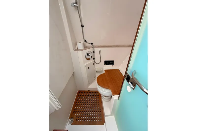 Slide: The Image of 2018 Pursuit DC 365 Dual Console boat bathroom with wooden accents and modern fixtures. - 49