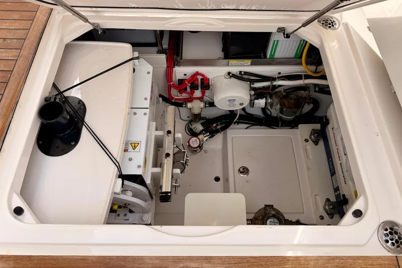 Slide: The Image of Engine compartment of a 2018 Pursuit DC 365 Dual Console boat, showcasing mechanical components. - 53