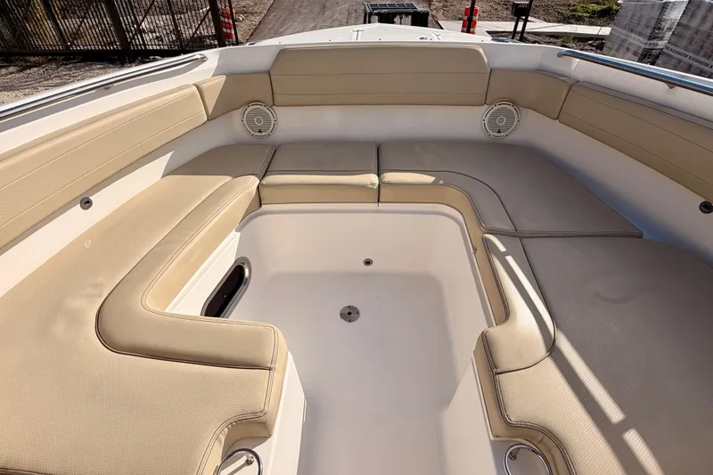 Slide: The Image of 2018 Pursuit DC 365 Dual Console boat interior with beige seating and speakers. - 8