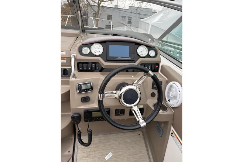 Slide: The Image of 2016 Regal 2660 Express Cruiser helm with steering wheel and control panel. - 10