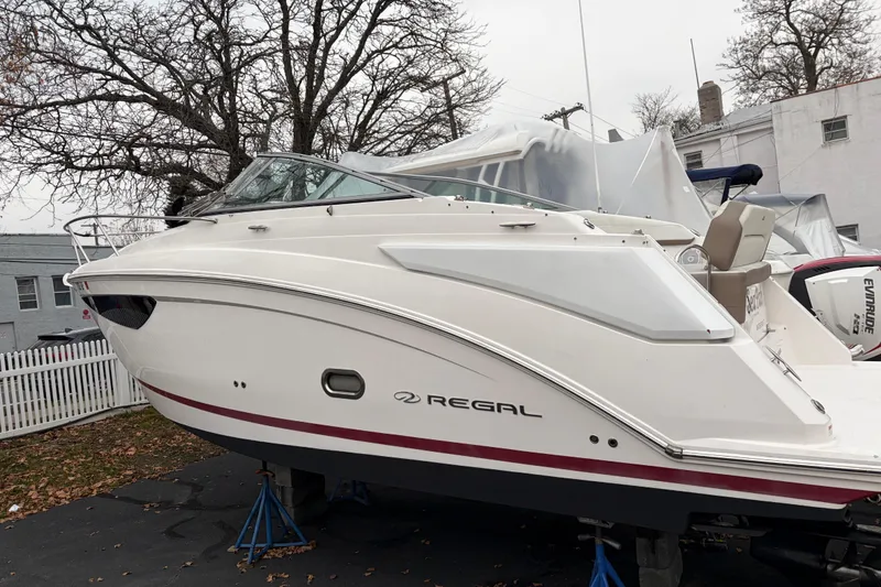 Slide: The Image of 2016 Regal 2660 Express Cruiser boat on stands, parked outdoors. - 11