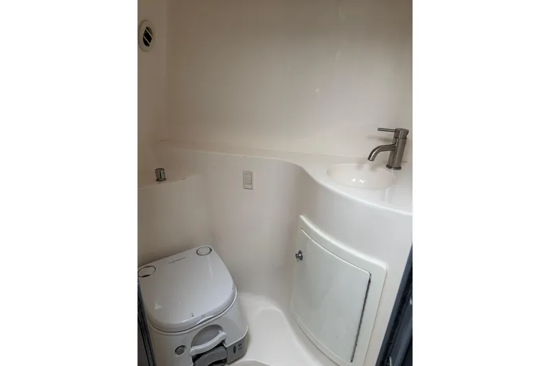 Slide: The Image of 2016 Regal 2660 Express Cruiser bathroom with compact toilet and sink. - 8