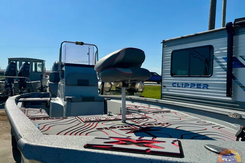 Slide: The Image of 2024 Express SW20B BAY boat interior with seating, parked near a Clipper trailer. - 25