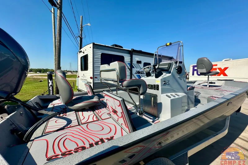 Slide: The Image of 2024 Express SW20B BAY boat with modern seating and control panel, parked near RV and FedEx truck. - 4