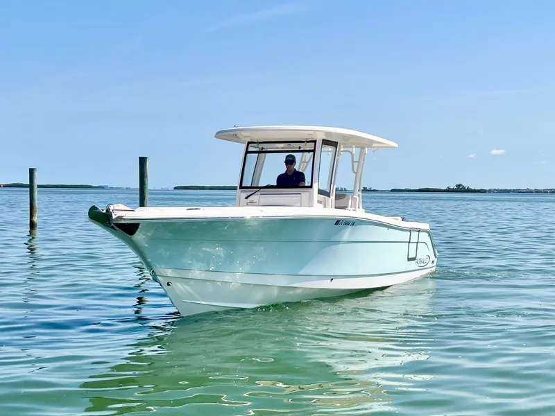 The Image of 2020 Robalo R302 Center Console boat on calm water under clear blue sky. - 0