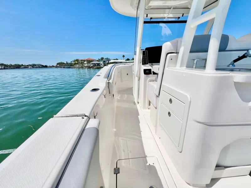 Slide: The Image of 2020 Robalo R302 Center Console boat on calm water, showcasing sleek design and spacious deck. - 11