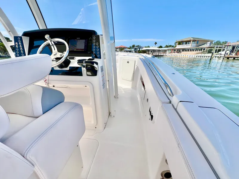 Slide: The Image of 2020 Robalo R302 Center Console boat interior with steering wheel, dockside view. - 17