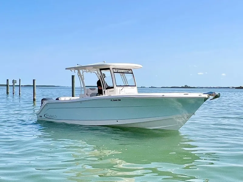 Slide: The Image of 2020 Robalo R302 Center Console boat on calm water under clear blue sky. - 2