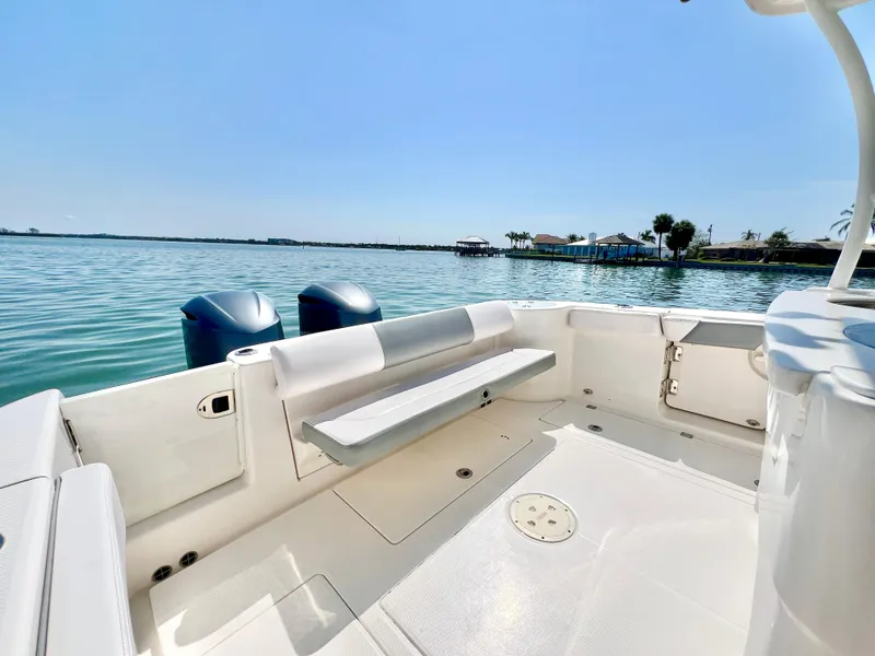 Slide: The Image of 2020 Robalo R302 Center Console boat with spacious deck and twin engines on calm water. - 6