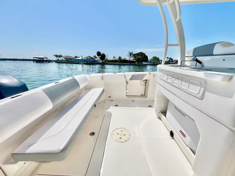 Slide: The Image of 2020 Robalo R302 Center Console boat interior with seating, on a sunny day by the water. - 7