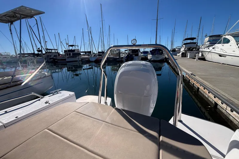 Slide: The Image of 2022 Axopar 28 AFT CABIN boat docked in a marina under clear blue skies. - 10