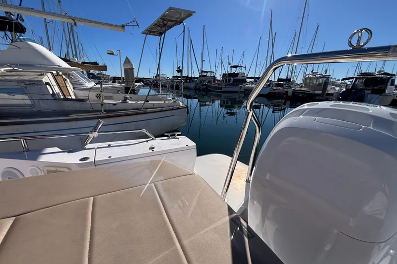 Slide: The Image of 2022 Axopar 28 AFT CABIN boat docked in a marina with clear blue sky. - 11