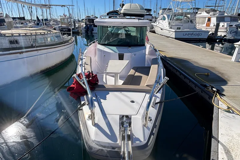 Slide: The Image of 2022 Axopar 28 AFT CABIN boat docked at marina, surrounded by other vessels. - 14