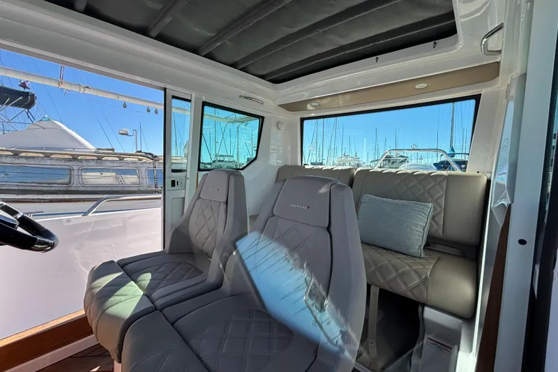 Slide: The Image of Interior of 2022 Axopar 28 AFT CABIN with luxurious seating and marina view. - 16