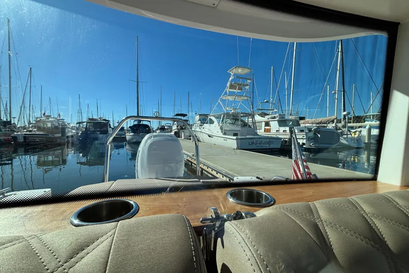 Slide: The Image of View from 2022 Axopar 28 AFT CABIN, overlooking marina with boats and clear blue sky. - 19