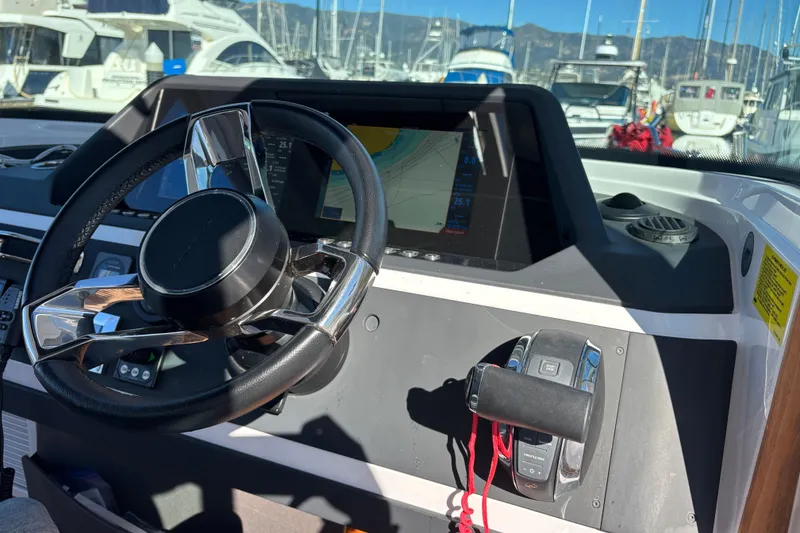 Slide: The Image of 2022 Axopar 28 AFT CABIN helm with steering wheel and navigation display. - 25