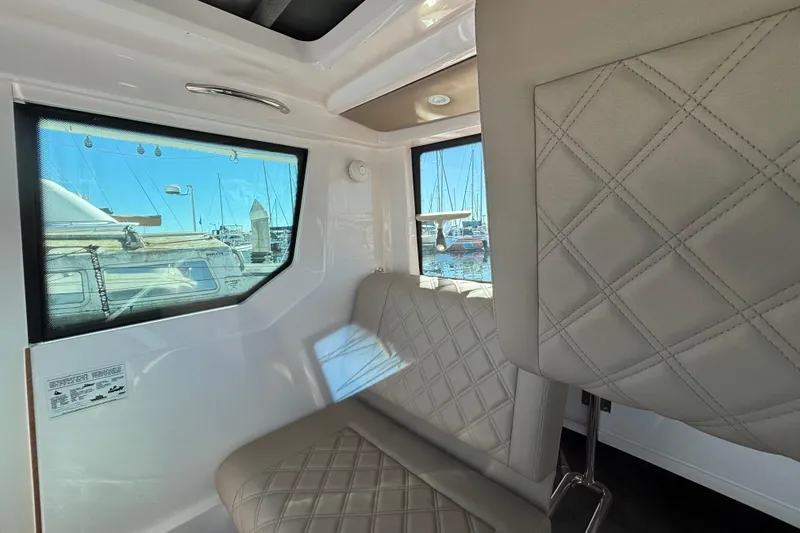 Slide: The Image of Interior of 2022 Axopar 28 AFT CABIN with quilted seating and marina view. - 31