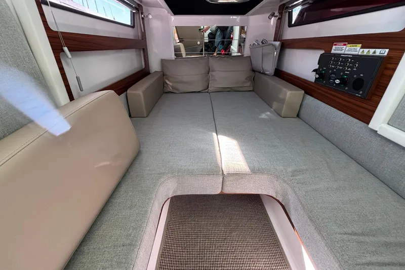 Slide: The Image of 2022 Axopar 28 AFT CABIN interior with cozy seating and control panel. - 36