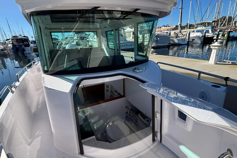 Slide: The Image of 2022 Axopar 28 AFT CABIN boat docked at marina, showcasing cabin entrance. - 46