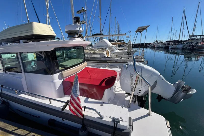 Slide: The Image of 2022 Axopar 28 AFT CABIN boat docked in marina with American flag. - 6