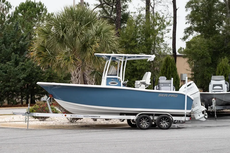 The Image of 2026 Sea Pro 222 Center Console boat on trailer, parked near trees. - 1