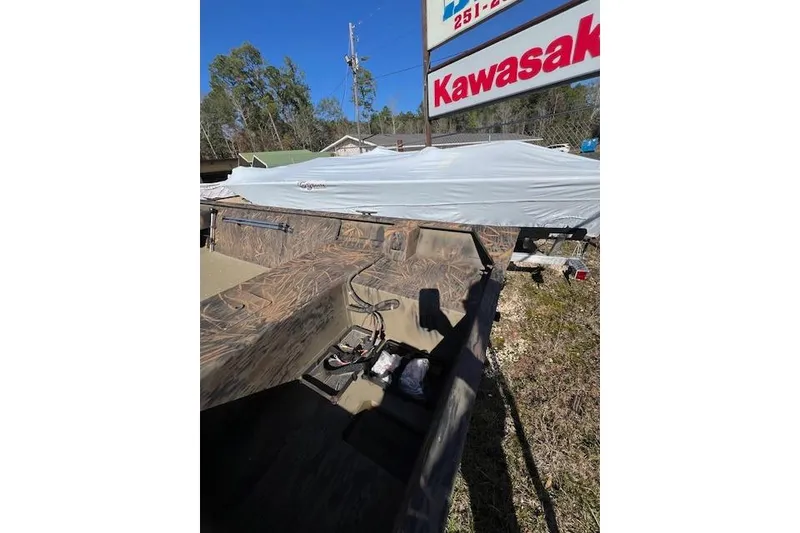 Slide: The Image of 2026 G3 Gator Tough 15 FL boat with camouflage interior near Kawasaki sign. - 1