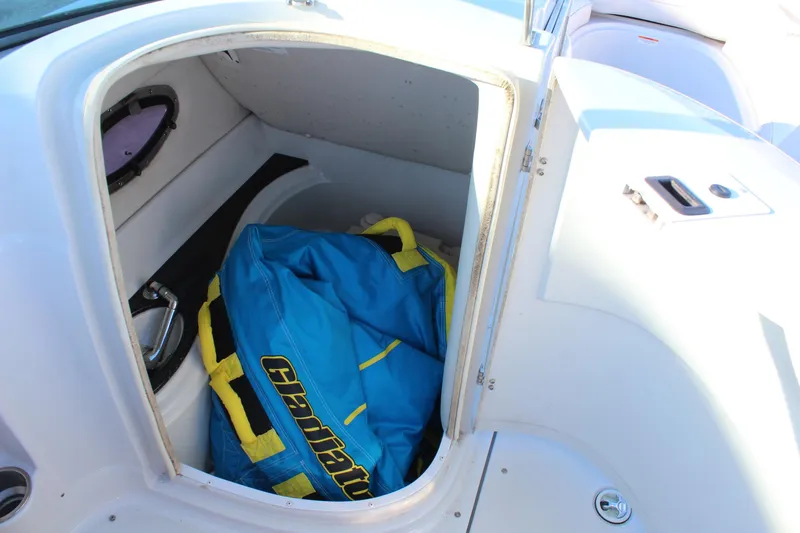 Slide: The Image of Storage compartment on 2007 Crownline 240 EX boat with blue and yellow life jacket. - 18