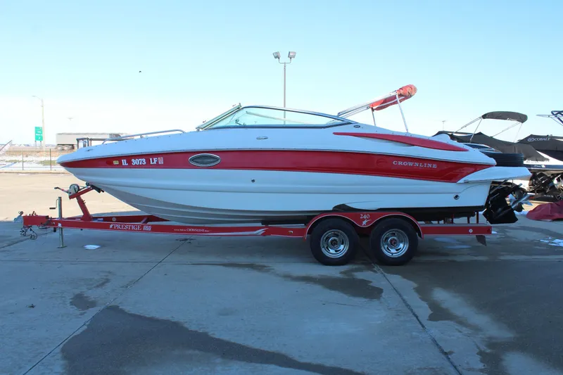 Slide: The Image of 2007 Crownline 240 EX boat on trailer, red and white design, parked outdoors. - 5