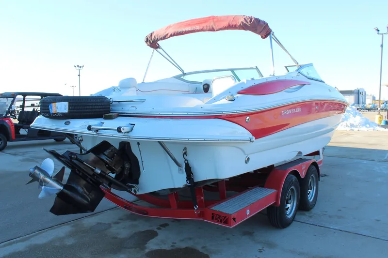 Slide: The Image of 2007 Crownline 240 EX boat on trailer, red and white design, parked outdoors. - 8