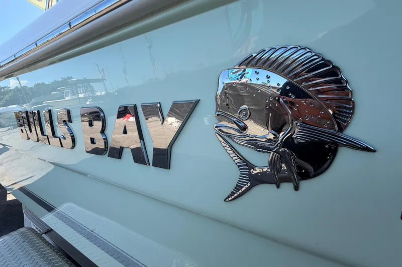 Slide: The Image of 2025 Bulls Bay 255 Center Console boat with chrome fish emblem. - 11