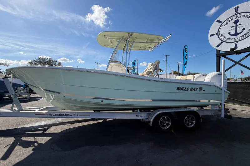 Slide: The Image of 2025 Bulls Bay 255 Center Console boat on trailer under clear blue sky. - 12