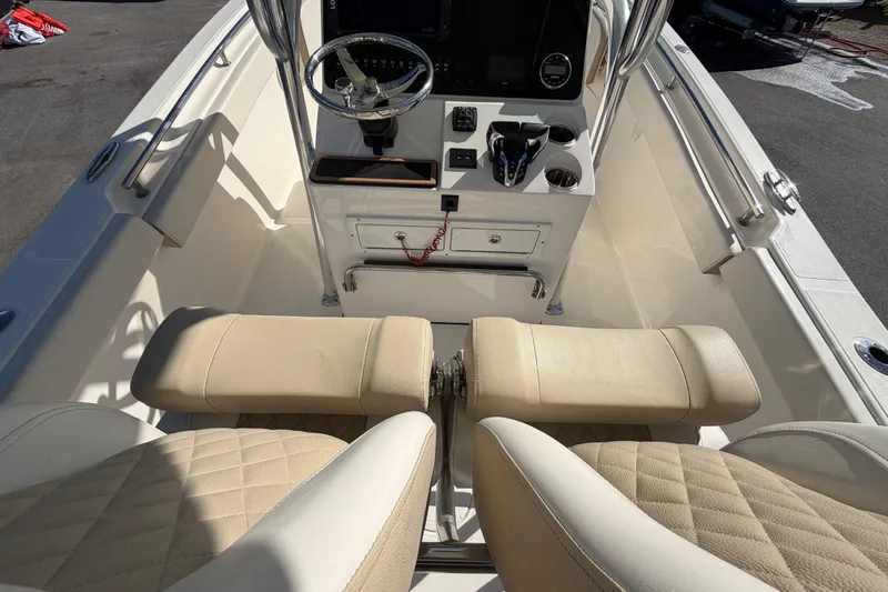 Slide: The Image of 2025 Bulls Bay 255 Center Console boat interior with beige seating and control panel. - 25